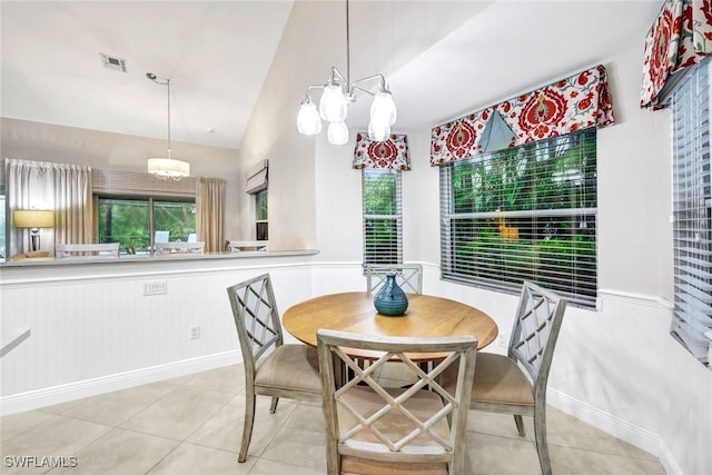 dining area featuring light tile patterned floors, lofted ceiling, and an inviting chandelier