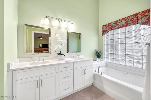 bathroom featuring tile patterned flooring, vanity, ceiling fan, and a tub