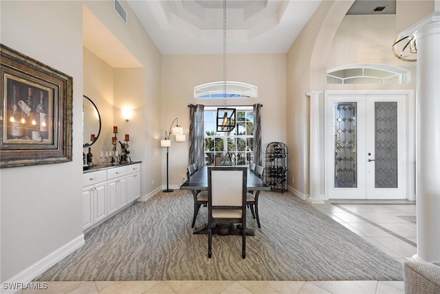 dining area featuring light tile patterned floors, french doors, visible vents, and baseboards