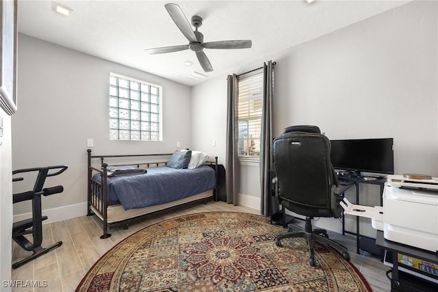 bedroom with ceiling fan, light wood-style floors, and baseboards