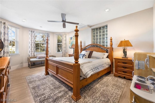 bedroom featuring light wood-style flooring, a ceiling fan, and baseboards