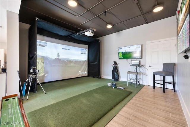 playroom featuring golf simulator, baseboards, and wood finished floors