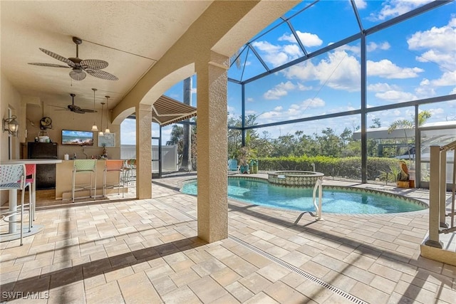 view of pool featuring outdoor dry bar, a patio, ceiling fan, and glass enclosure