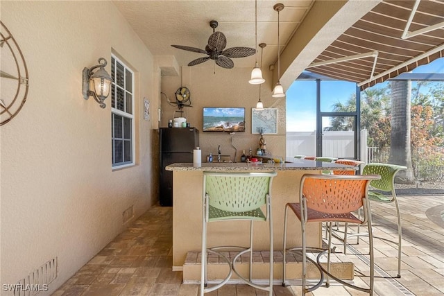 view of patio / terrace featuring ceiling fan and an outdoor bar