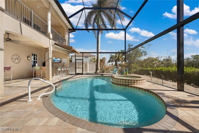 view of swimming pool featuring a ceiling fan, glass enclosure, a patio, and outdoor dry bar