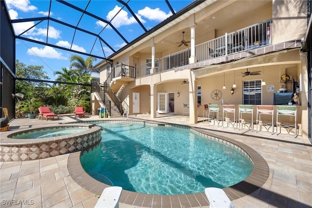 view of swimming pool with glass enclosure, a patio area, an in ground hot tub, and exterior bar