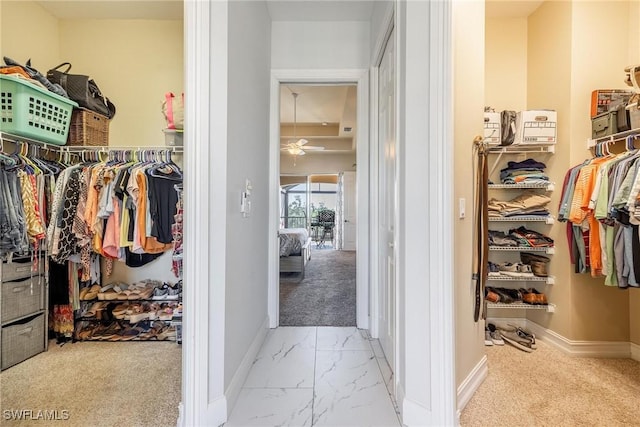 walk in closet with light carpet, marble finish floor, and a ceiling fan