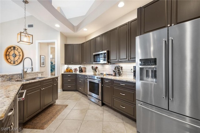 kitchen featuring pendant lighting, visible vents, appliances with stainless steel finishes, a sink, and dark brown cabinetry