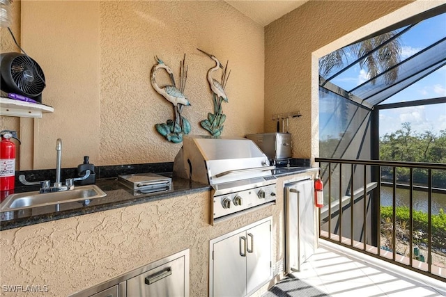 view of patio with exterior kitchen, a lanai, a sink, and area for grilling