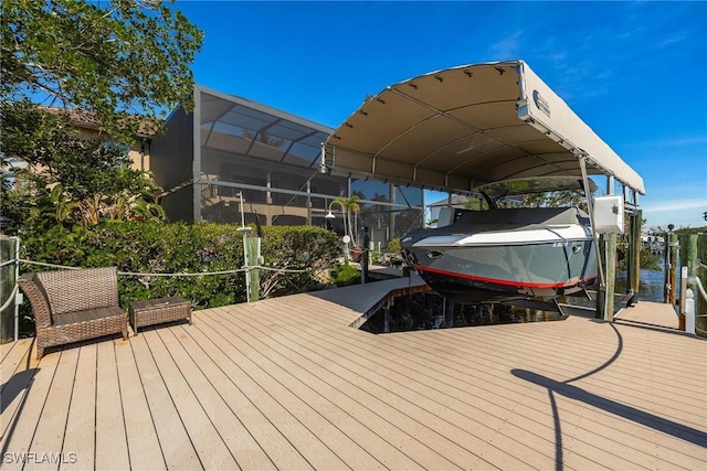 deck with boat lift, a water view, a boat dock, a carport, and a lanai