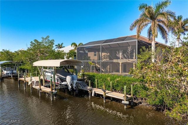 dock area with a water view, glass enclosure, and boat lift