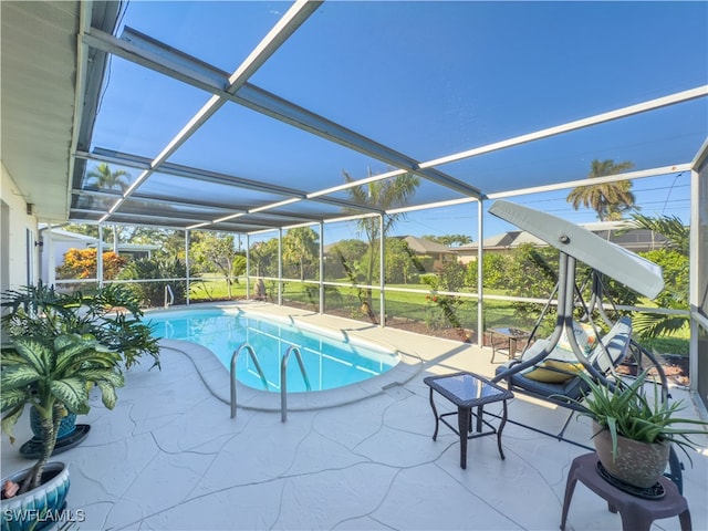 view of pool featuring glass enclosure and a patio area