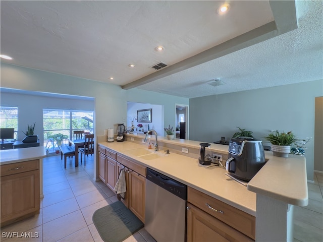 kitchen featuring stainless steel dishwasher, light tile patterned floors, sink, and a textured ceiling