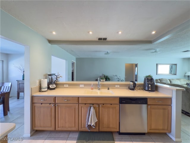 kitchen with stainless steel dishwasher, light tile patterned floors, sink, and a textured ceiling