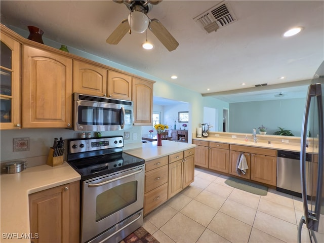 kitchen featuring appliances with stainless steel finishes, light tile patterned floors, ceiling fan, and sink