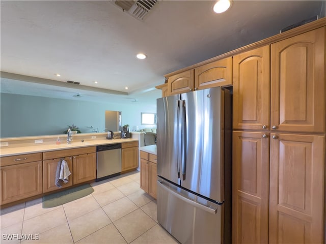 kitchen featuring appliances with stainless steel finishes, light tile patterned floors, and sink