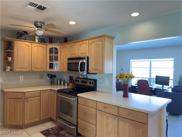 kitchen with kitchen peninsula, ceiling fan, light tile patterned floors, and stainless steel appliances