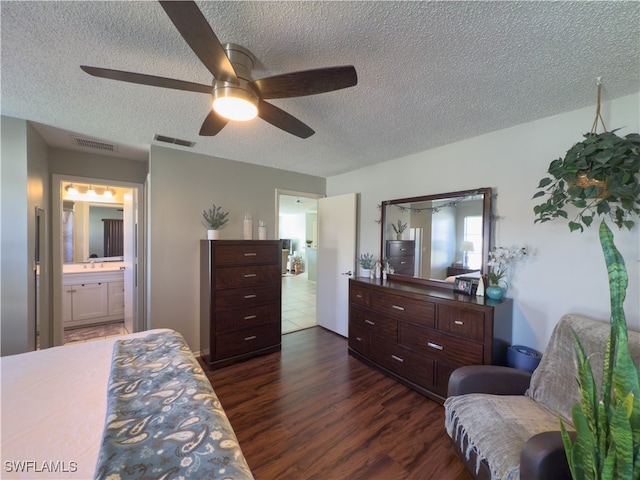 bedroom featuring ceiling fan, dark hardwood / wood-style flooring, a textured ceiling, and connected bathroom