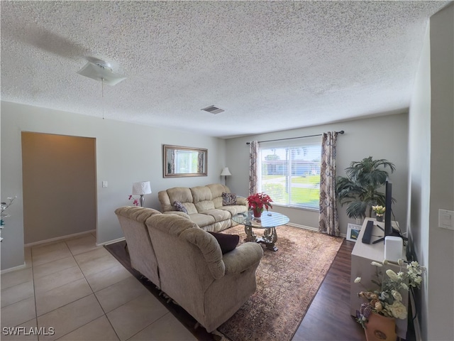 tiled living room featuring a textured ceiling