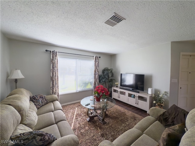 living room featuring a textured ceiling and dark wood-type flooring