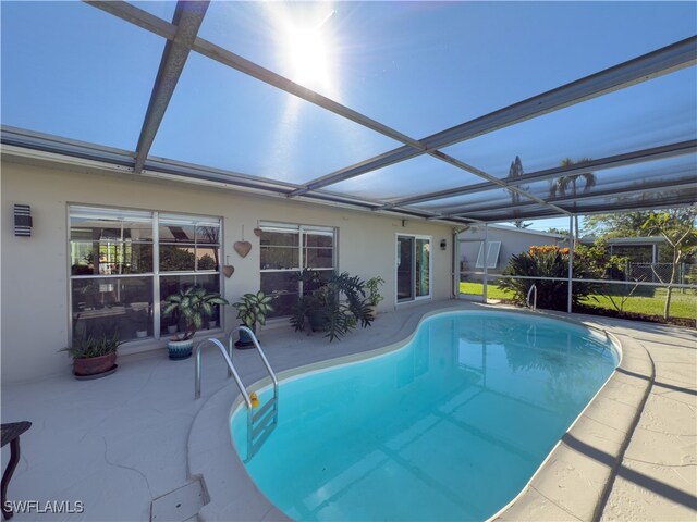 view of swimming pool with a lanai and a patio area