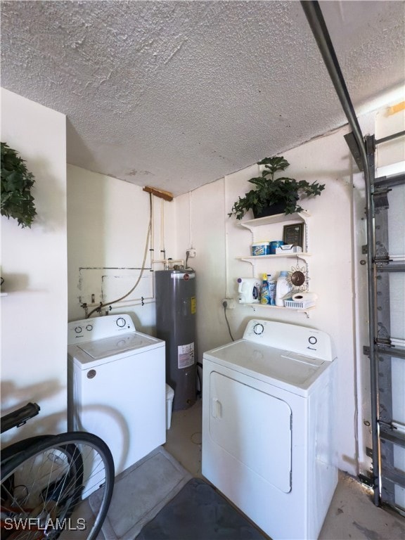 laundry room with electric water heater, washer and dryer, and a textured ceiling