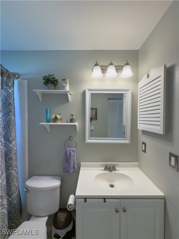 bathroom with vanity, a shower with shower curtain, and toilet