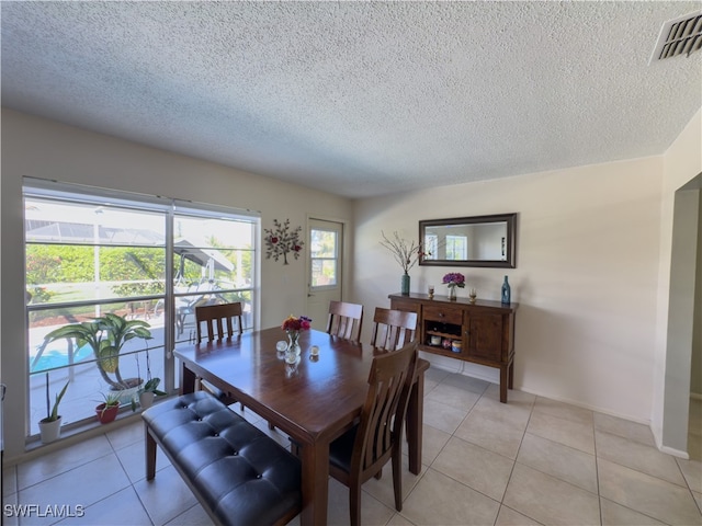 tiled dining room with a textured ceiling