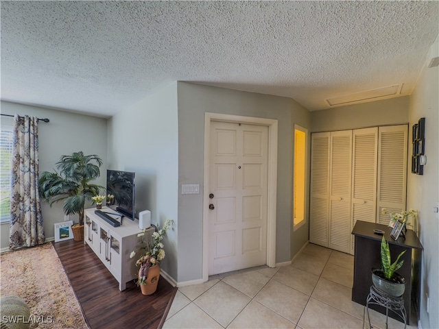 tiled foyer entrance with a textured ceiling