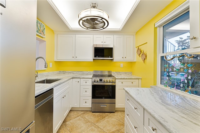 kitchen featuring white cabinets, sink, light tile patterned floors, light stone countertops, and appliances with stainless steel finishes