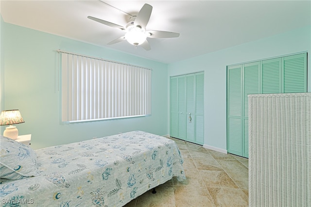 bedroom with ceiling fan and multiple closets