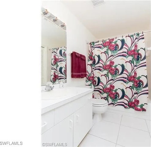 bathroom with tile patterned flooring, vanity, and toilet