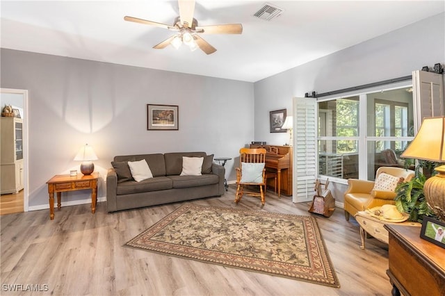 living room with ceiling fan and light hardwood / wood-style floors