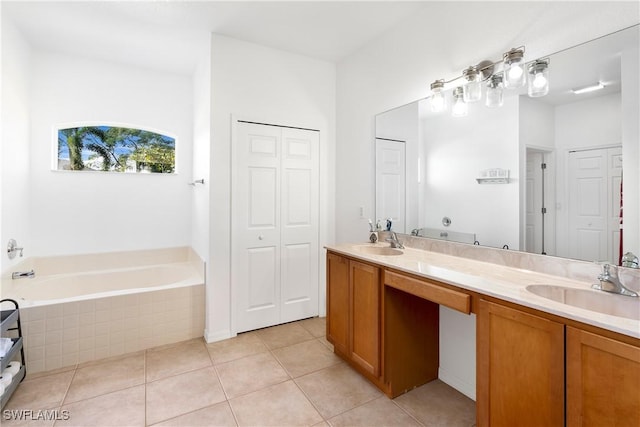 bathroom with tile patterned floors, vanity, and tiled bath