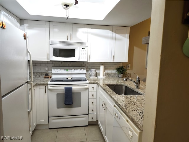 kitchen featuring tasteful backsplash, white cabinetry, sink, and white appliances