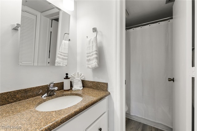 bathroom with toilet, vanity, and hardwood / wood-style flooring