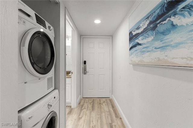 laundry area featuring light wood-type flooring and stacked washing maching and dryer