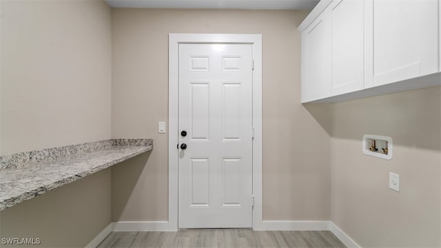 clothes washing area featuring cabinets, hookup for a washing machine, and light hardwood / wood-style flooring