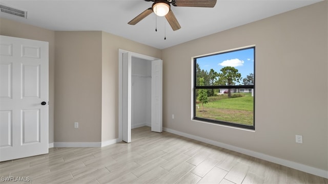 unfurnished bedroom featuring ceiling fan, light hardwood / wood-style floors, and a closet