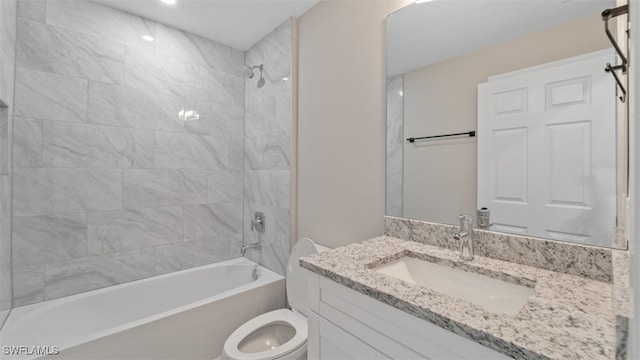 full bathroom featuring vanity, tiled shower / bath combo, and toilet