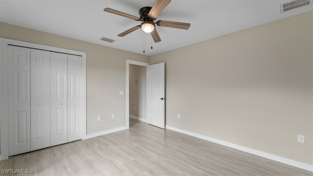 unfurnished bedroom featuring ceiling fan, light hardwood / wood-style floors, and a closet