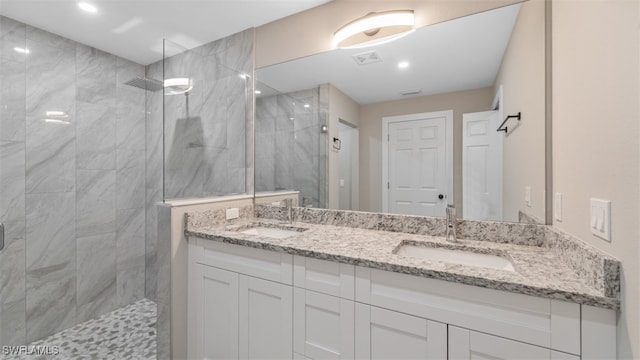 bathroom with vanity and a tile shower