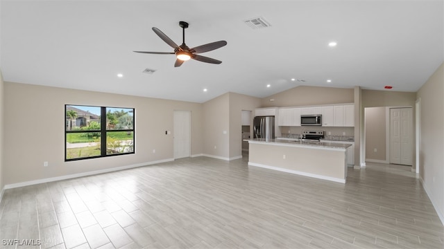 unfurnished living room with ceiling fan, light wood-type flooring, and vaulted ceiling