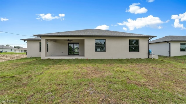 back of house with a patio, ceiling fan, and a lawn