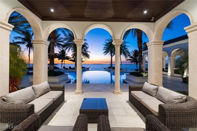 patio terrace at dusk with a water view and outdoor lounge area