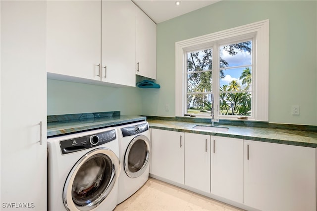 washroom featuring cabinets, separate washer and dryer, and sink