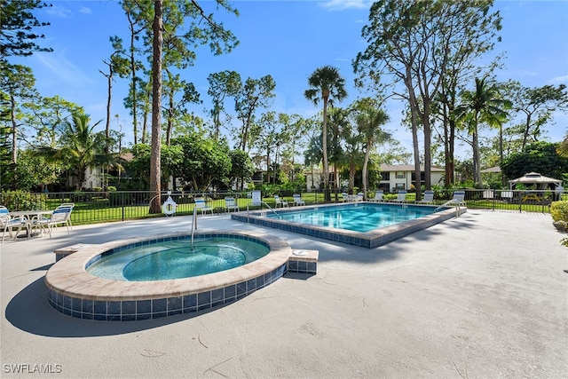 view of swimming pool featuring a hot tub