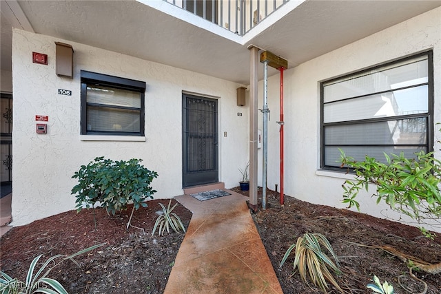 view of exterior entry with a balcony