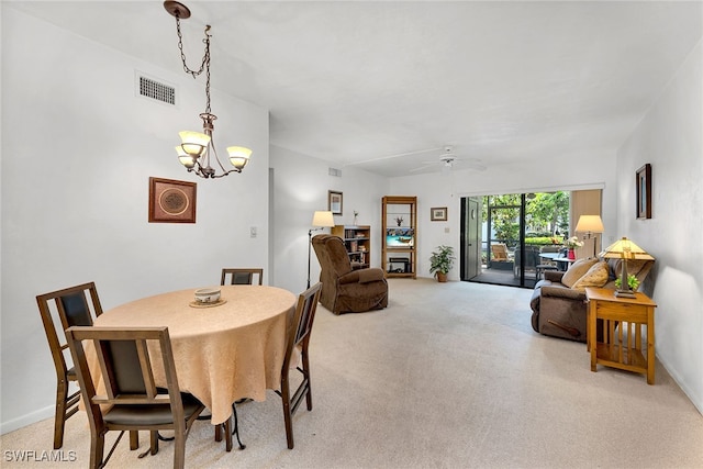 carpeted dining area featuring ceiling fan with notable chandelier