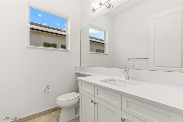 bathroom with hardwood / wood-style floors, vanity, and toilet